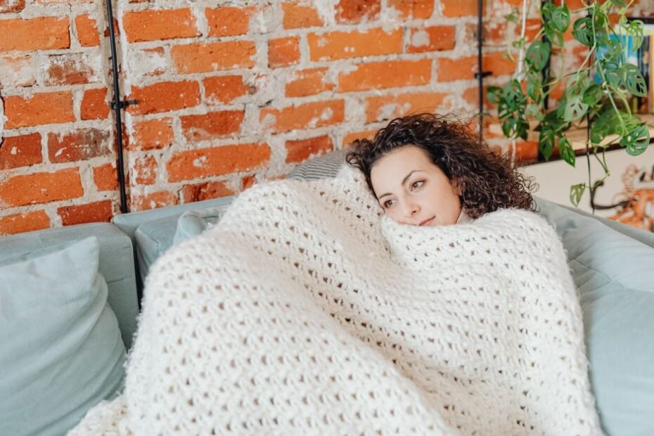 Woman wrapped in a cozy blanket enjoying soothing warmth and comfort