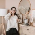 Woman enjoying a bright, cozy morning with coffee and a lamp
