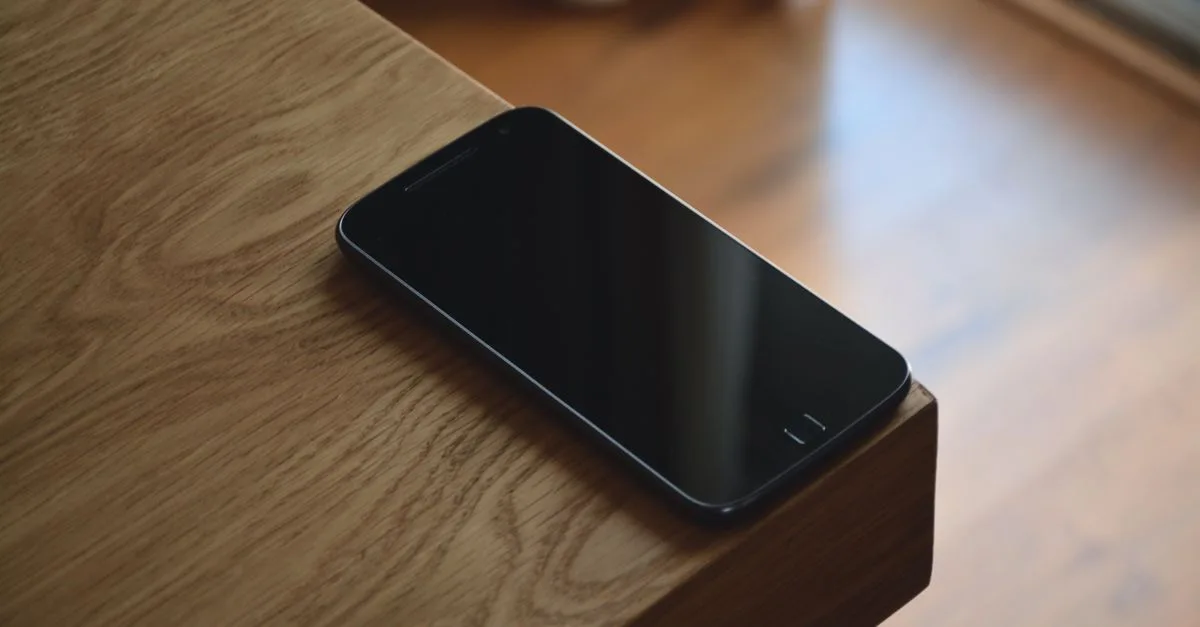 Phone lying face down on a wooden table