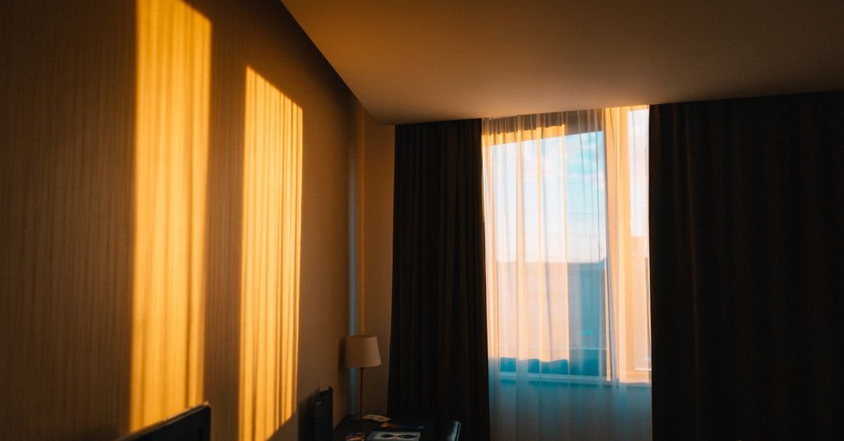 Golden sunrise light streaming through a bedroom window
