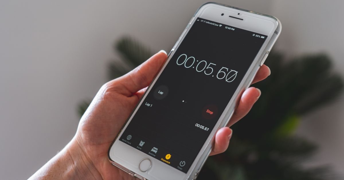 A hand holding a phone with a timer running
