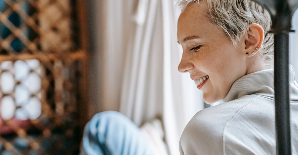 Woman smiling gently, looking content and grateful