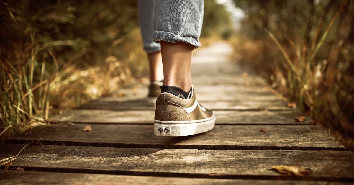 Feet walking mindfully along a wooden path