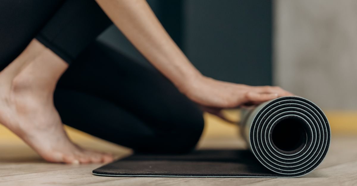 Person unrolling a comfortable mat on the floor