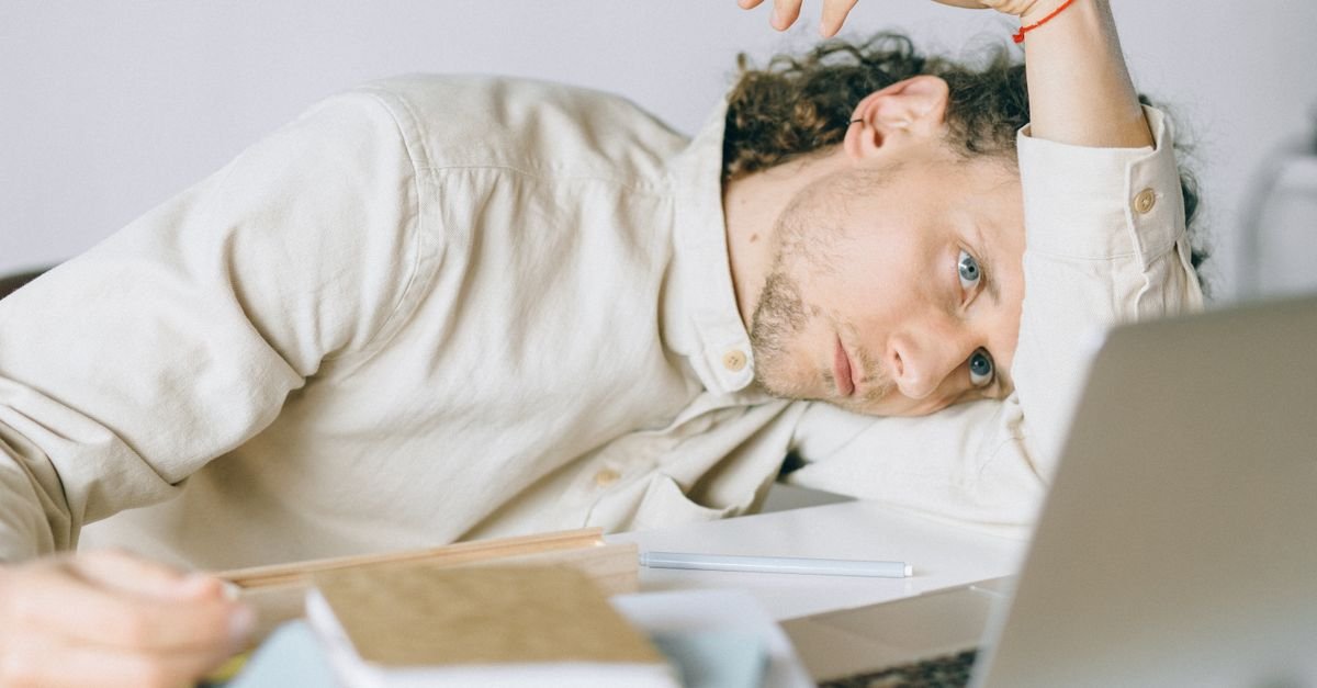 Tired person taking a moment at a busy work desk