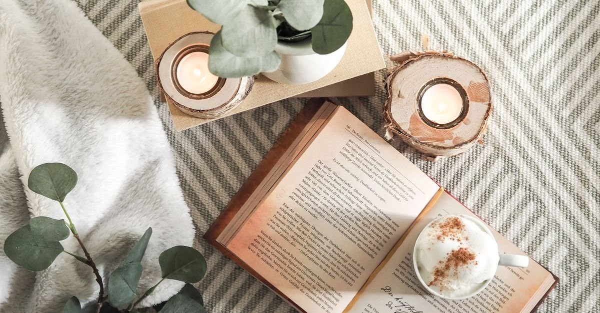 Cozy candles, a book and a soft blanket for a calm evening