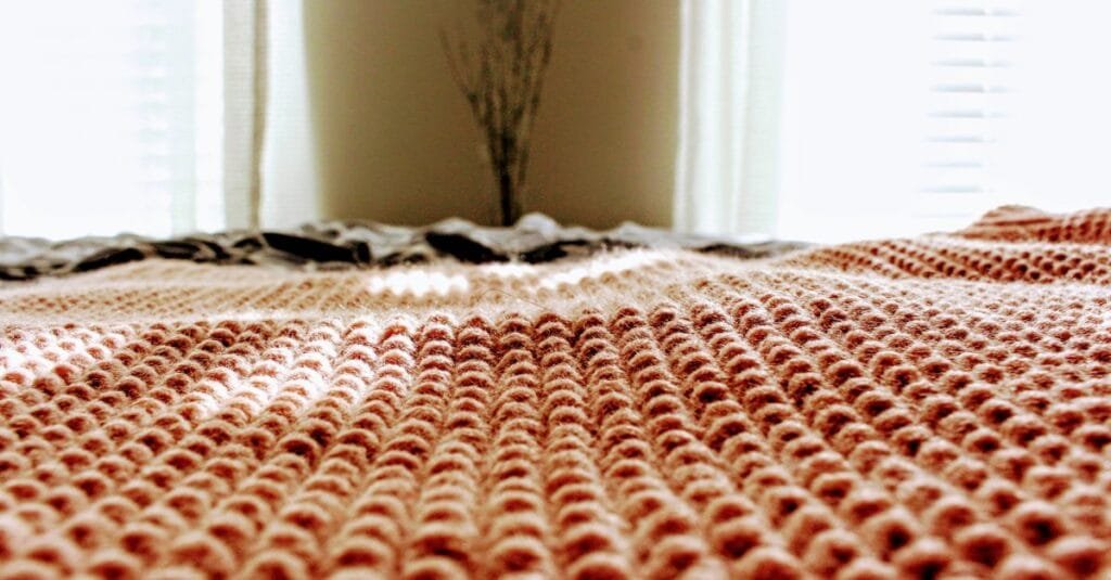 A cozy knit blanket on the bed