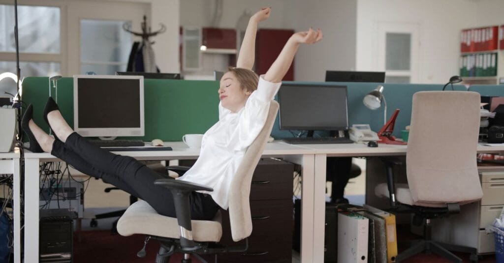 Woman stretching at her desk during work