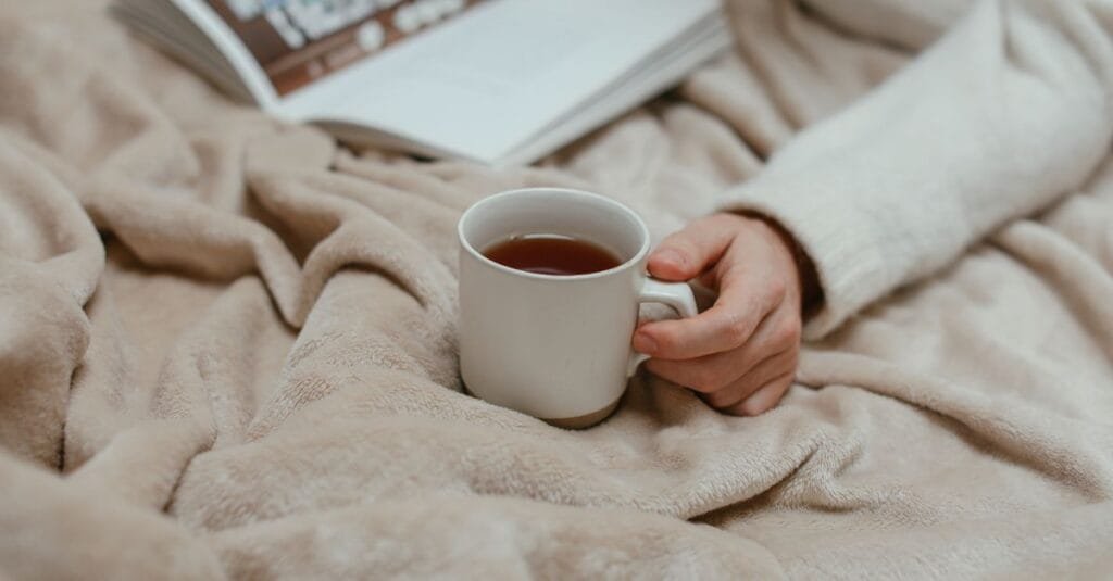 A warm cup of tea and a book in bed